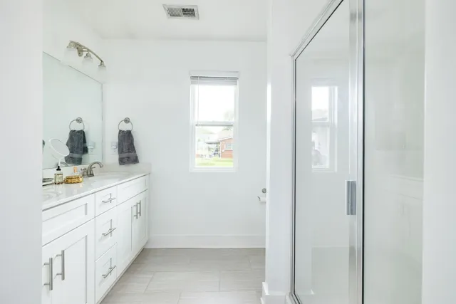 a bathroom with double vanity sinks and a mirror