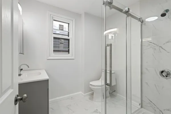 a bathroom with a toilet a sink and shower