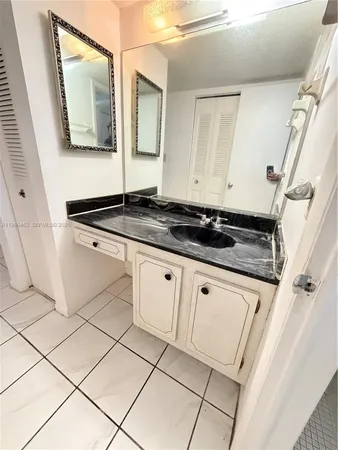 a bathroom with granite countertop a sink and a mirror