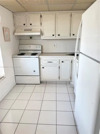 a kitchen with white cabinets and white appliances