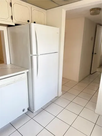 a white refrigerator freezer and a stove sitting inside of a kitchen