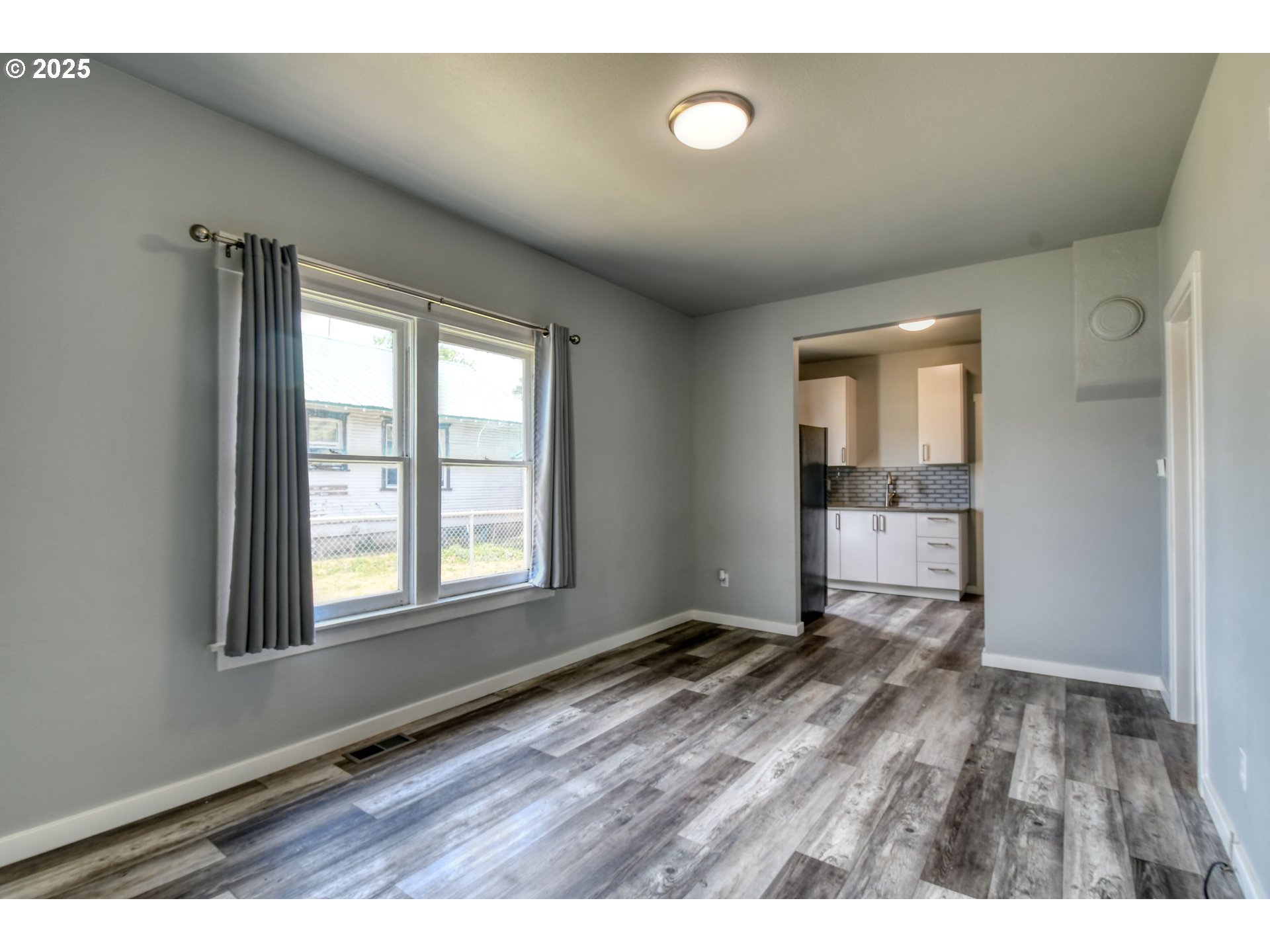 1408 Southwest Frazer Avenue Pendleton, OR 97801 - Photo 5 of 24 an empty room with wooden floor and windows
