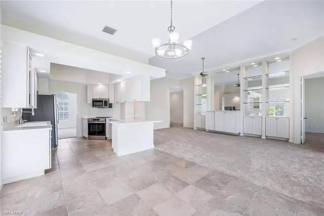 a view of a kitchen with refrigerator and white cabinets