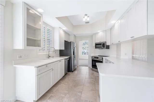 a large kitchen with a sink dishwasher stove and refrigerator