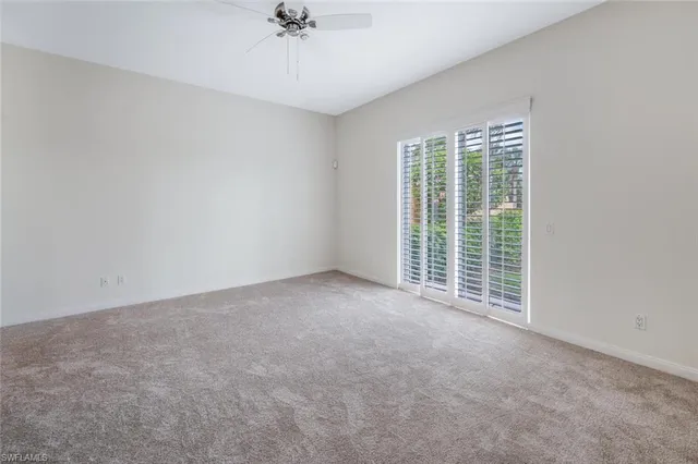 a view of a livingroom with a ceiling fan and window