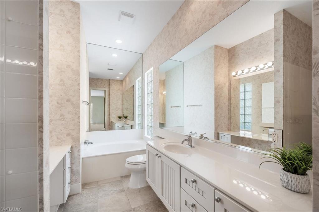 8511 Alessandria Court Naples, FL 34114 - Photo 20 of 45 a spacious bathroom with a double vanity sink toilet mirror and bathtub
