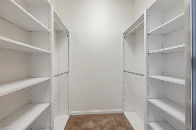 a view of walk in closet with empty racks