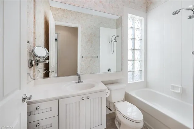 a bathroom with a toilet a sink a tub and mirror