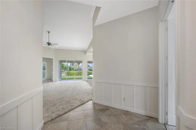 a view of hallway with wooden floor and a window