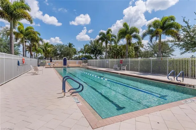 a view of swimming pool with a bench and trees