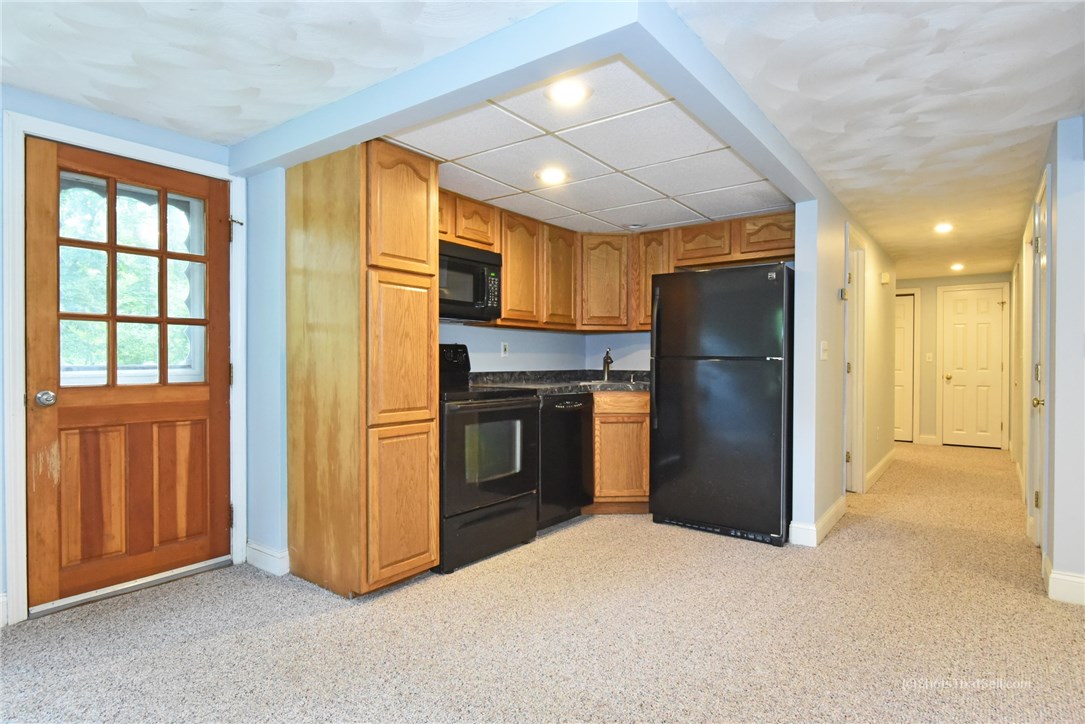 25 Edgewood Road Glocester, RI 02814 - Photo 24 of 33 Summer kitchen in the lower level with views of the hallway and walkout door.