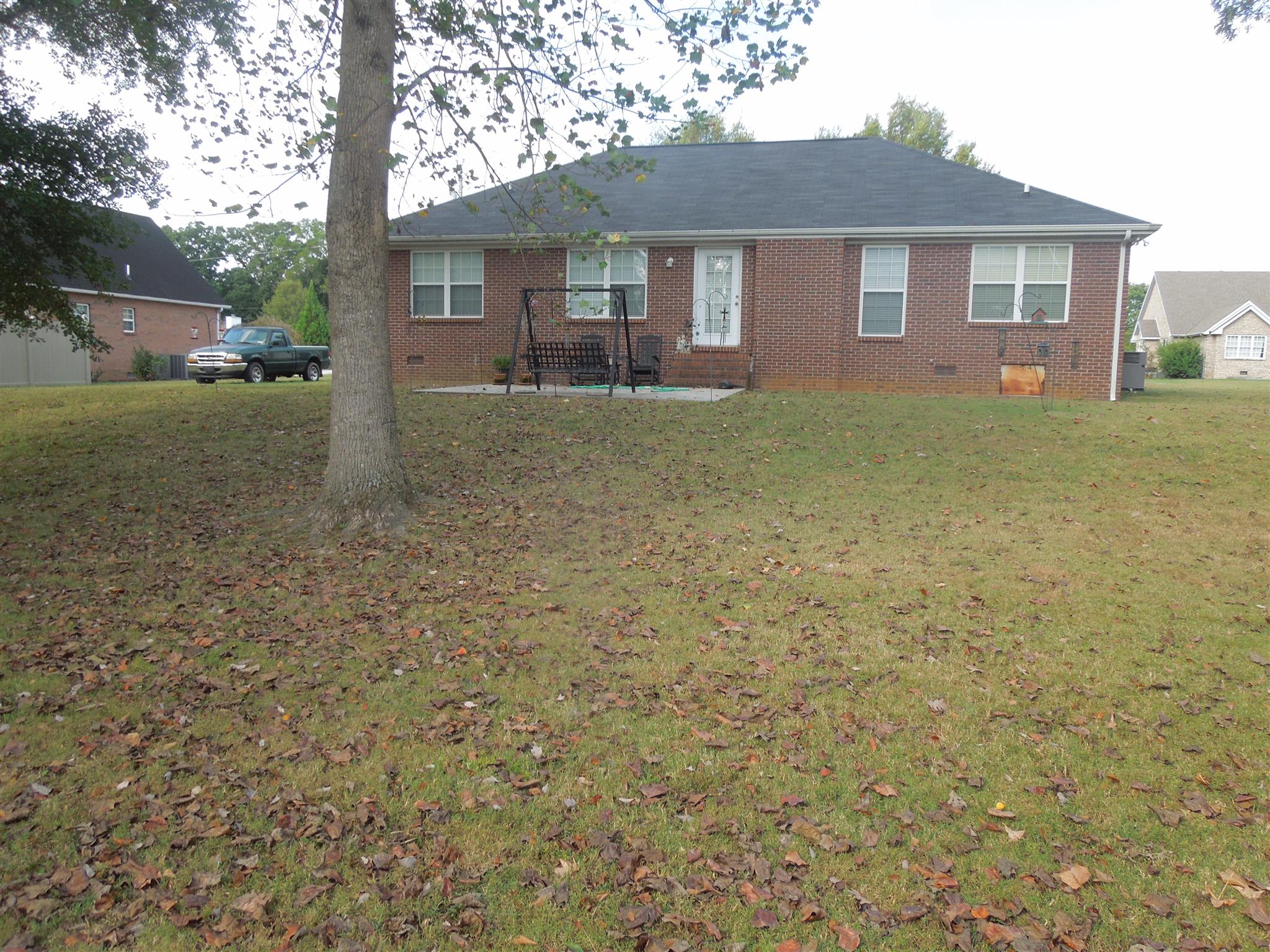 96 Hunt Creek Road Manchester, TN 37355 - Photo 5 of 13 a view of a yard in front of a brick house with large windows