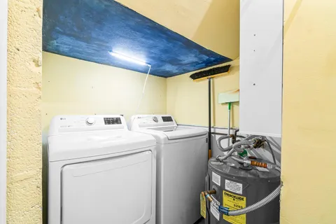 a view of a storage & utility room with refrigerator and windows
