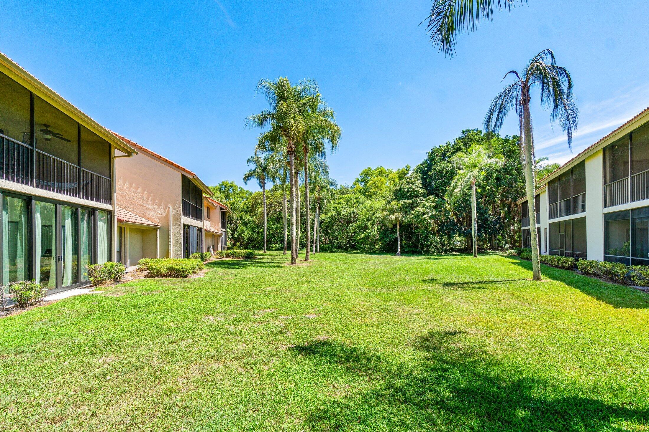 5750 Coach House Circle, Unit C Boca Raton, FL 33486 - Photo 26 of 30 a yellow house with a yard and palm trees
