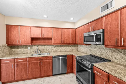 a kitchen with stainless steel appliances granite countertop a stove a refrigerator and a microwave