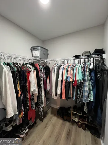 a view of walk in closet with clothes and shoes