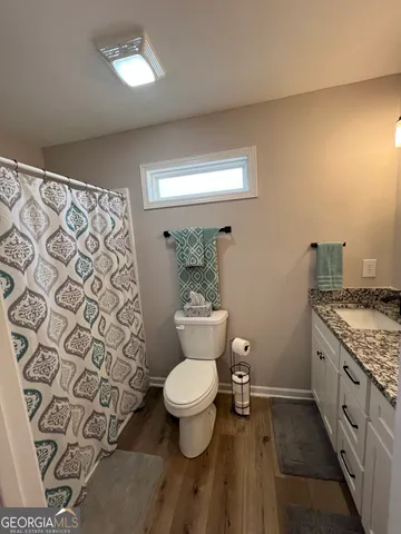 a bathroom with a granite countertop toilet and a sink