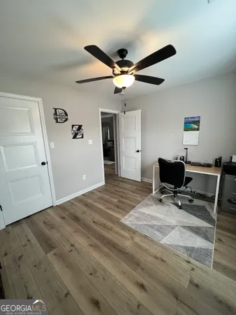 a workspace with wooden floor and a ceiling fan