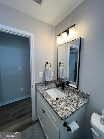 a bathroom with a granite countertop sink and a mirror