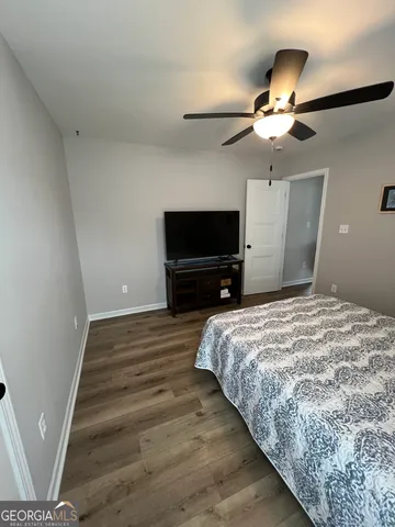a bedroom with a bed and a flat tv screen on dresser