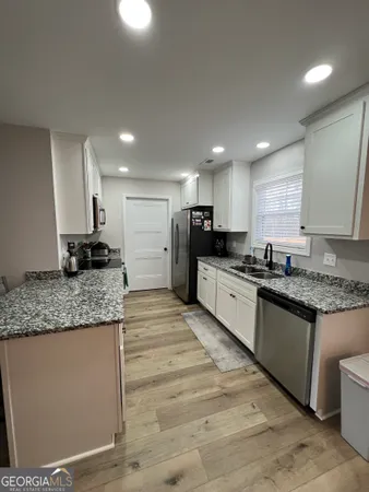 a large kitchen with stainless steel appliances granite countertop a stove a sink a refrigerator and a granite counter tops