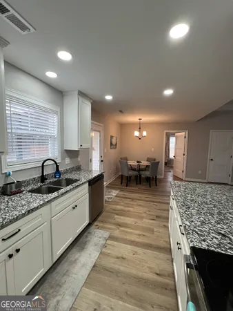 a large kitchen with stainless steel appliances granite countertop plenty wooden cabinets counter space a sink and a window