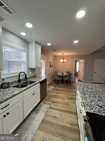 a large kitchen with stainless steel appliances granite countertop plenty wooden cabinets counter space a sink and a window
