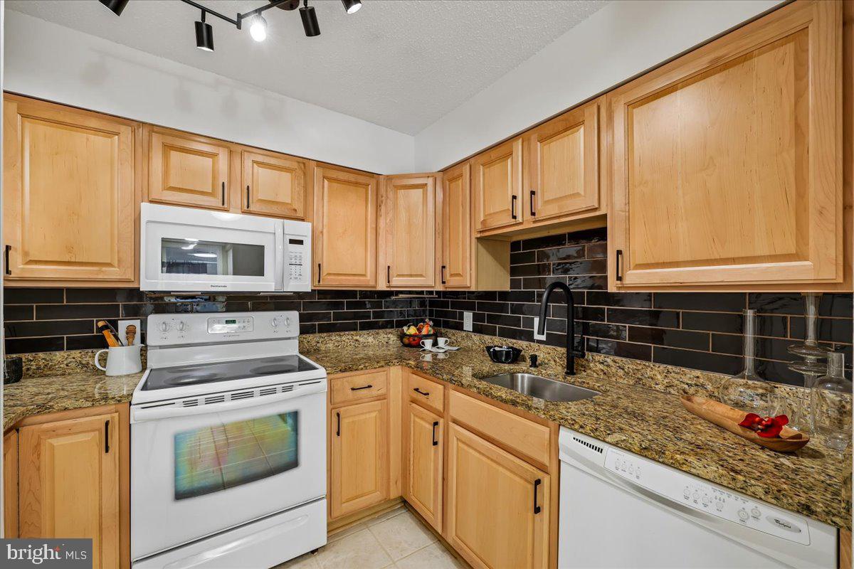 2111 Wisconsin Avenue Northwest, Unit 118 Washington, DC 20007 - Photo 12 of 61 a kitchen with stainless steel appliances granite countertop a stove a sink and a microwave