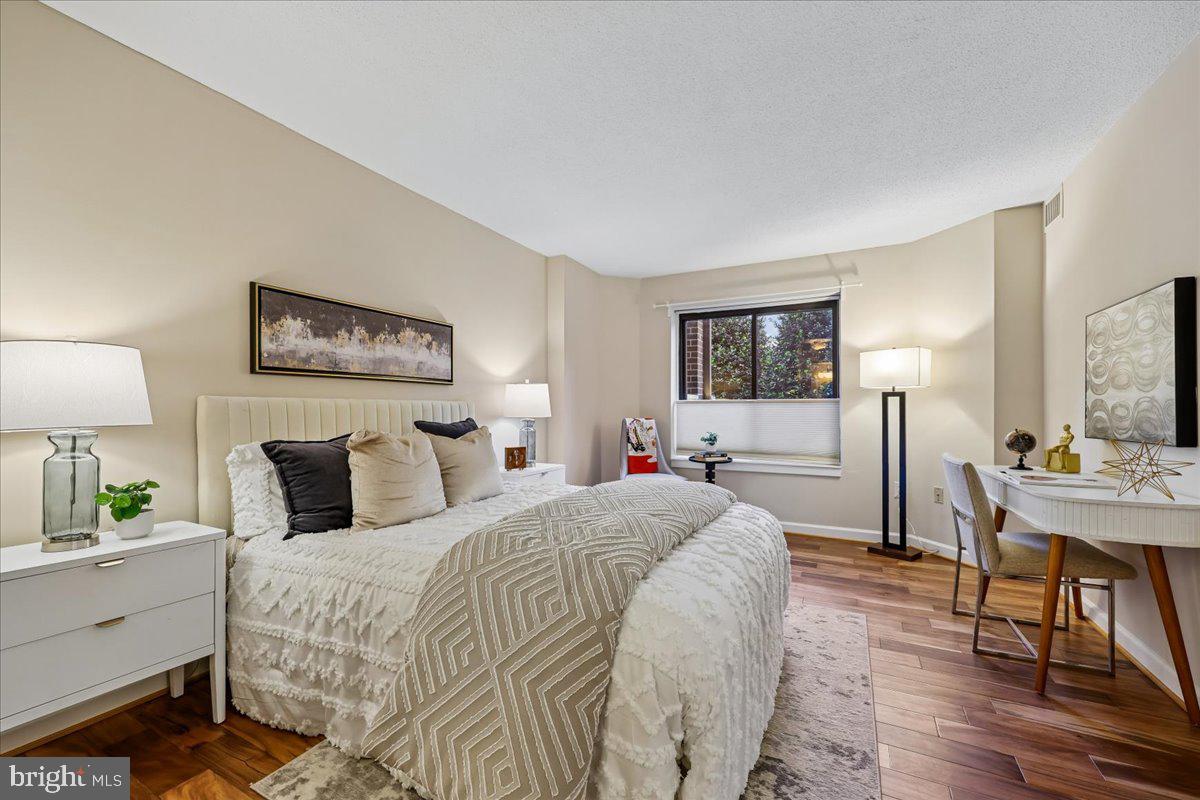 2111 Wisconsin Avenue Northwest, Unit 118 Washington, DC 20007 - Photo 24 of 61 a bedroom with a bed a mirror and table