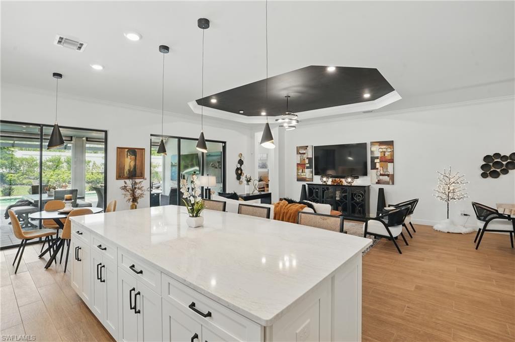 17467 Caravita Lane Fort Myers, FL 33913 - Photo 18 of 50 a large kitchen with stainless steel appliances a large center island attached withe living room