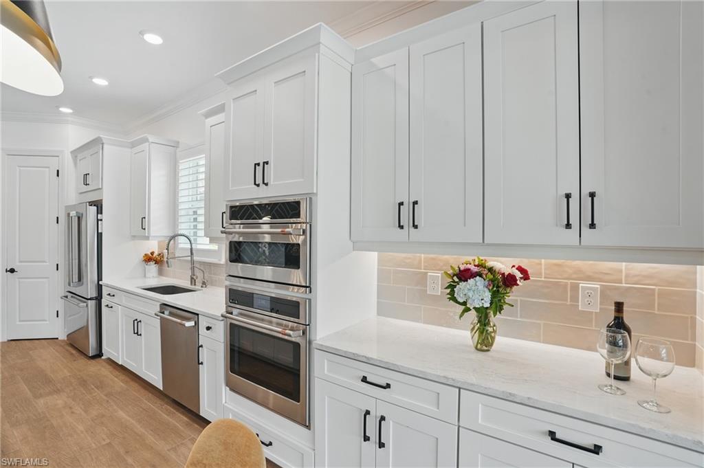 17467 Caravita Lane Fort Myers, FL 33913 - Photo 19 of 50 a kitchen with stainless steel appliances white cabinets and a sink