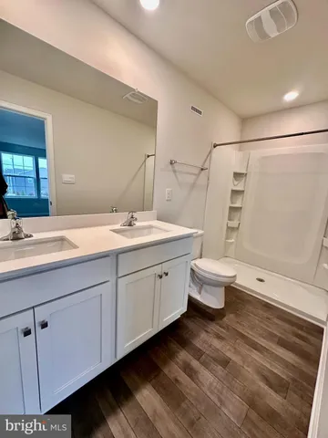 a spacious bathroom with a double vanity sink toilet and a shower