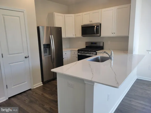 a kitchen with stainless steel appliances a refrigerator microwave and stove