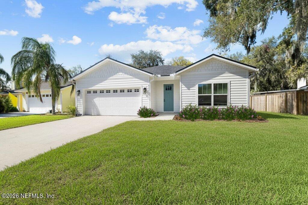9019 Hipps Road Jacksonville, FL 32222 - Photo 3 of 35 a front view of a house with a yard and garage