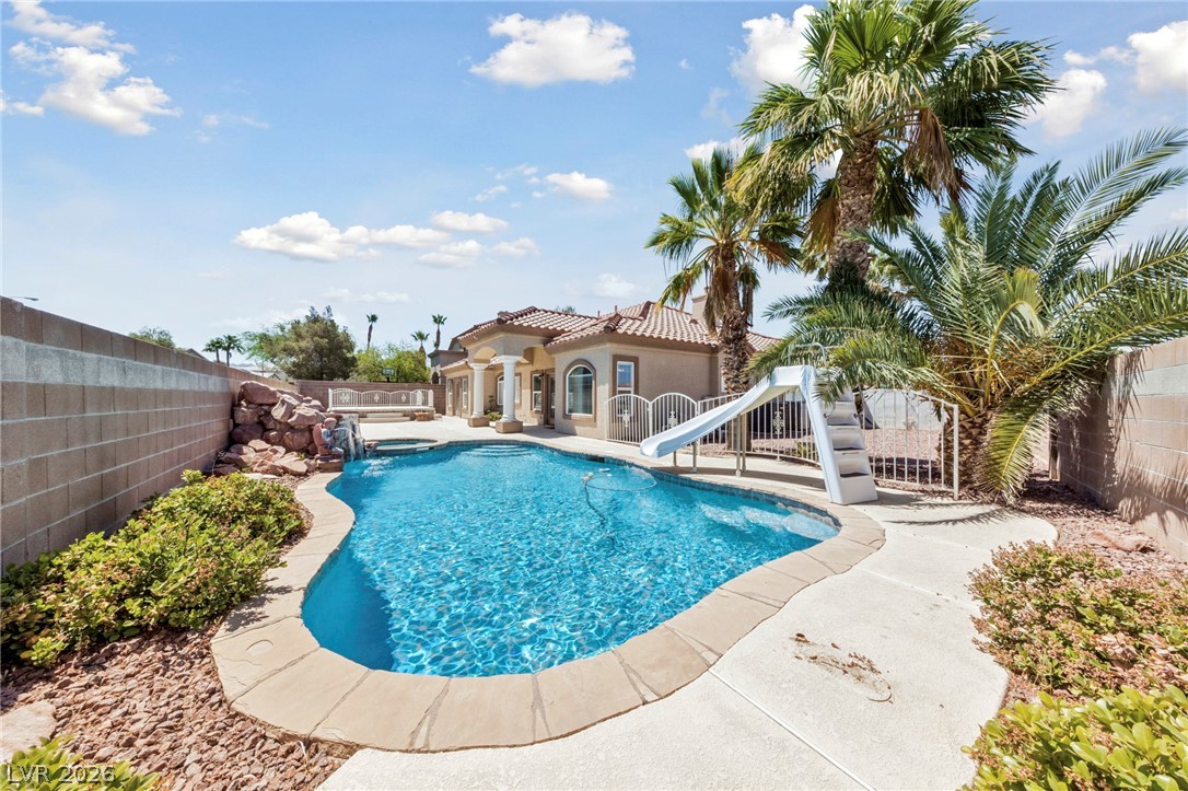 740 Aldo Rae Court, Unit NONE Henderson, NV 89052 - Photo 33 of 35 A custom-shaped pool with a rock waterfall and slide offers resort-style outdoor living.