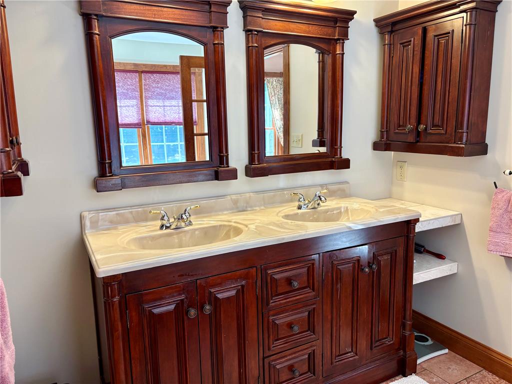 1222 Spring Road Andreas, PA 18211 - Photo 13 of 38 Double vanity with rich wood cabinetry and elegant stone countertops defines this primary bathroom's functionality.