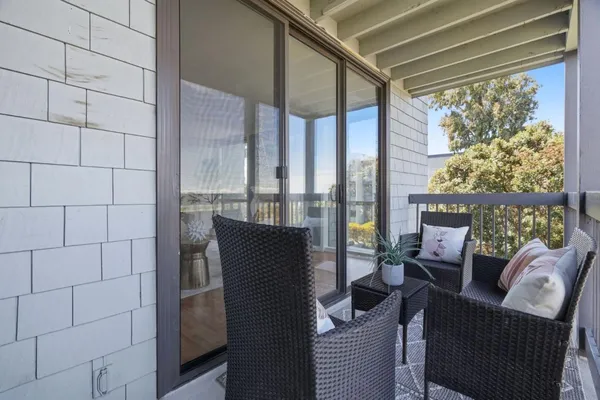 a balcony with chairs and with potted plants