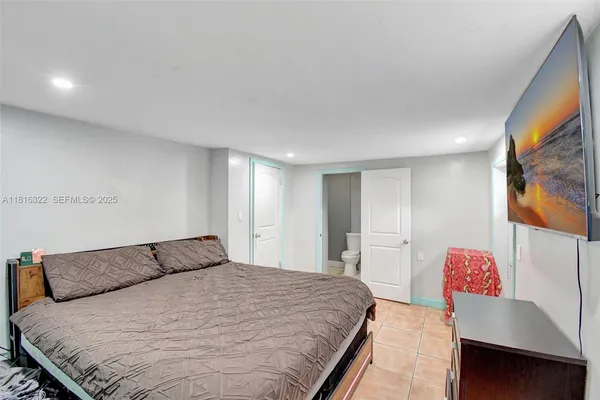 a bedroom with a large bed and a flat screen tv