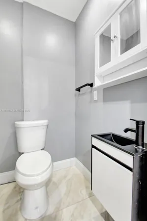 a bathroom with a toilet a sink and a window