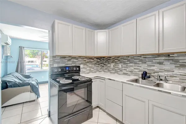 a kitchen with white cabinets a sink and appliances