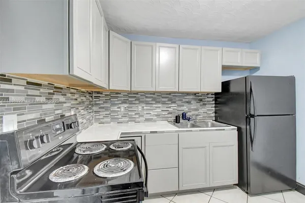 a kitchen with a stove sink and refrigerator