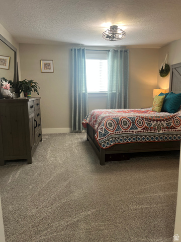 558 North N Cres Road Roosevelt, UT 84066 - Photo 17 of 31 Bedroom featuring light neutral wall paint, gray patterned carpet, a single window with blinds, and a built-in ceiling light fixture