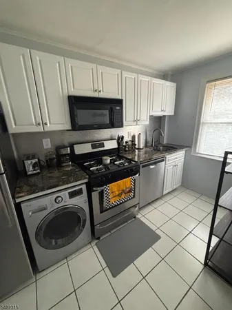 a kitchen with stainless steel appliances a stove a sink a microwave and cabinets