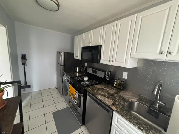 a kitchen with stainless steel appliances granite countertop a stove top oven a sink a counter space and cabinets