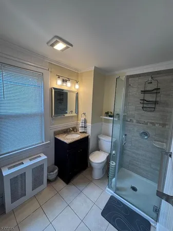 a bathroom with a granite countertop sink toilet mirror and shower