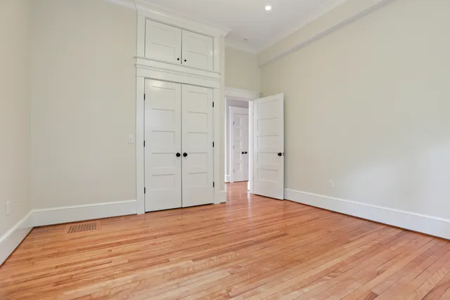 a view of an empty room with wooden floor