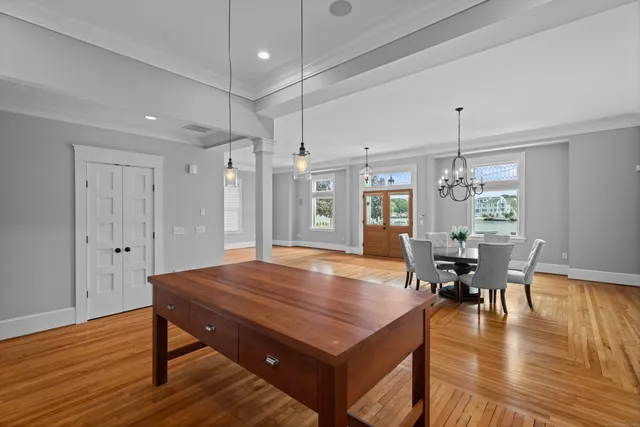 a room with dining table and wooden floor chairs