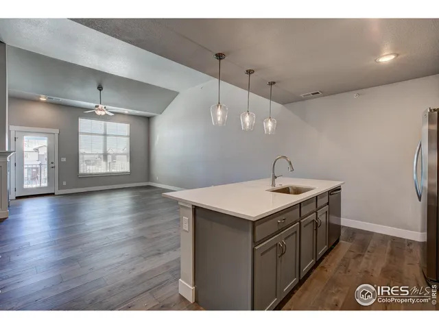 a kitchen with a sink and wooden floor
