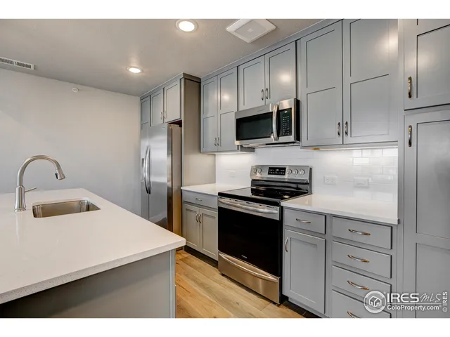 a kitchen that has a sink cabinets and stainless steel appliances