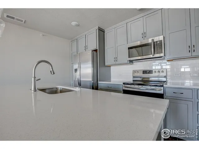a kitchen with stainless steel appliances granite countertop a sink a stove and a microwave